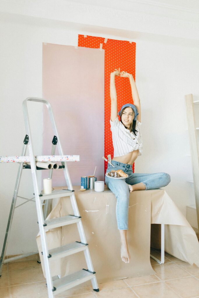 Woman enjoying a home renovation project with colorful wallpaper accents.